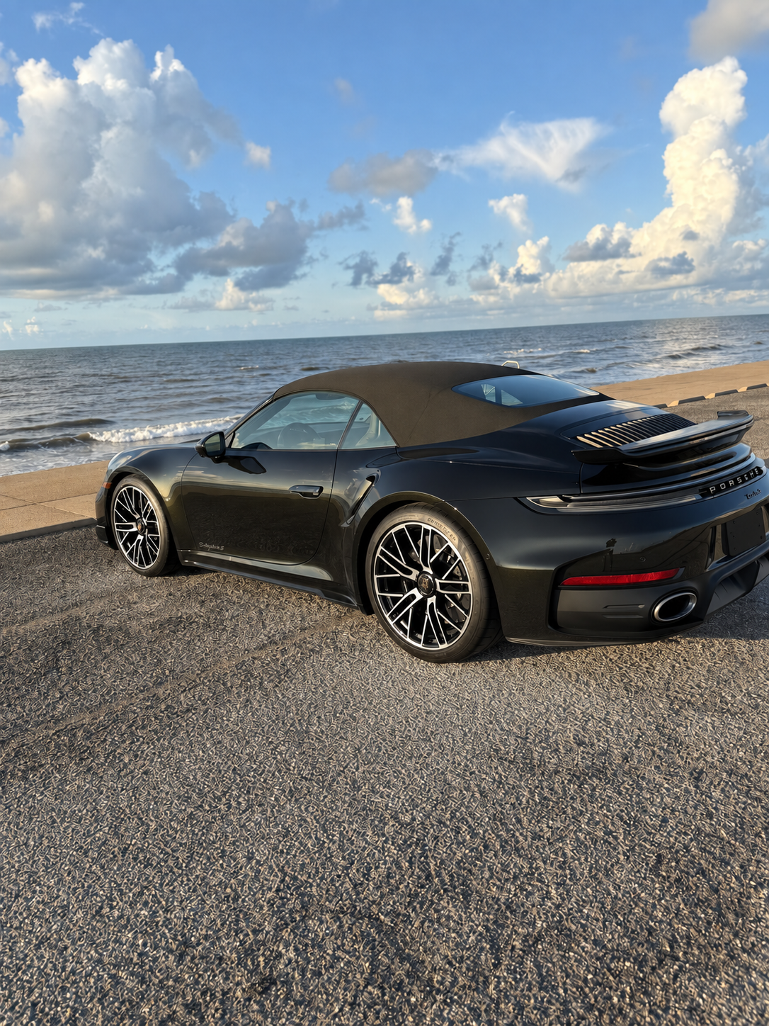 Dark Olive Green 2026 Porsche 911 Turbo S Cabriolet beside the Gulf of Mexico